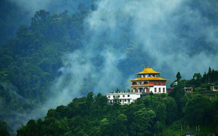 1563805981 view of a monastery in sikkim surrounded by lush greenery and fog ss28112016